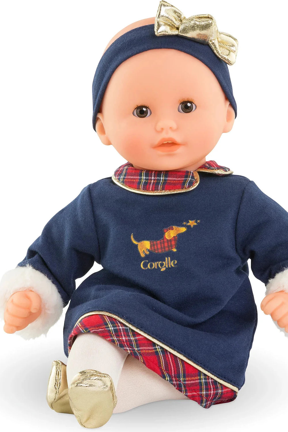 Baby Doll in Blue Dress with a dog on the dress and headband with gold bow, white tights and gold shoes. Plaid on the collar. 