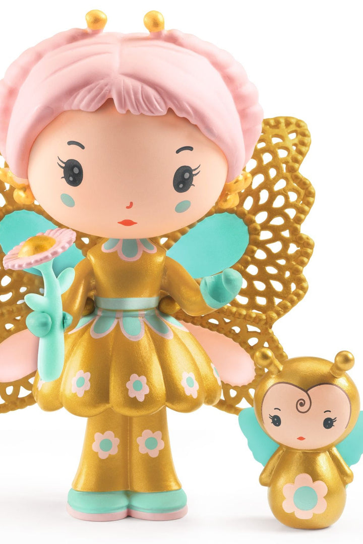Toy figure of a fairy with gold wings and pink hair, holding a smaller fairy figure.