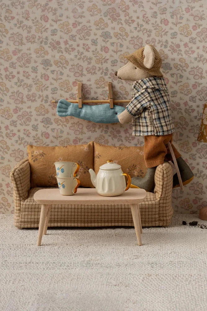 Two toy mice in a living room setting with furniture and decor.