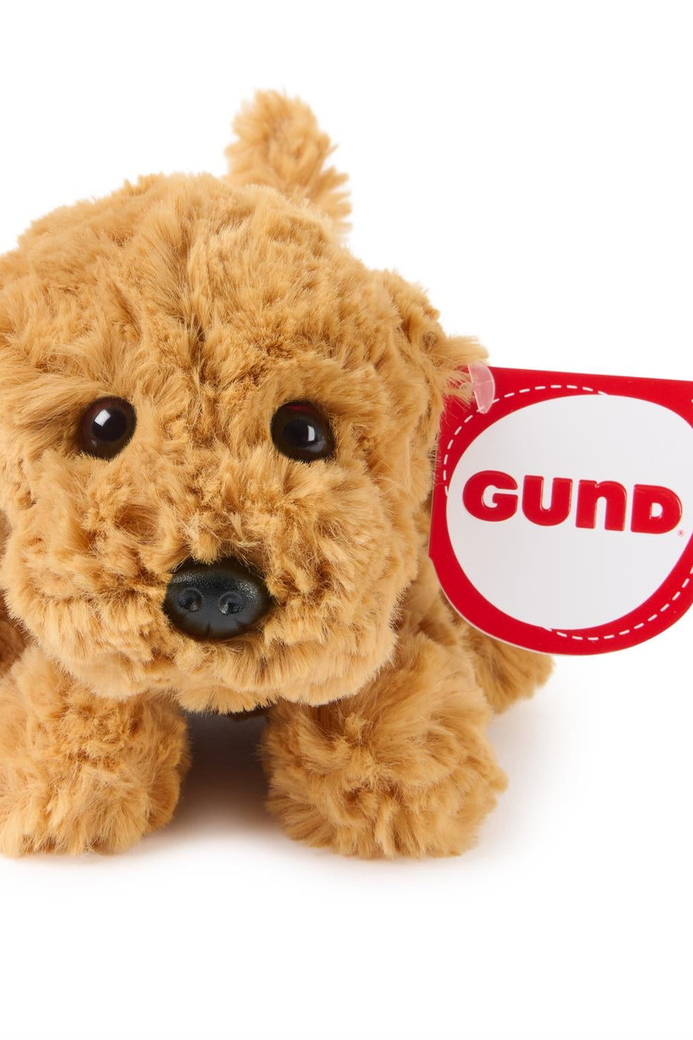 Photo of blonde dog stuffed animal with a gund tag written in red on ear