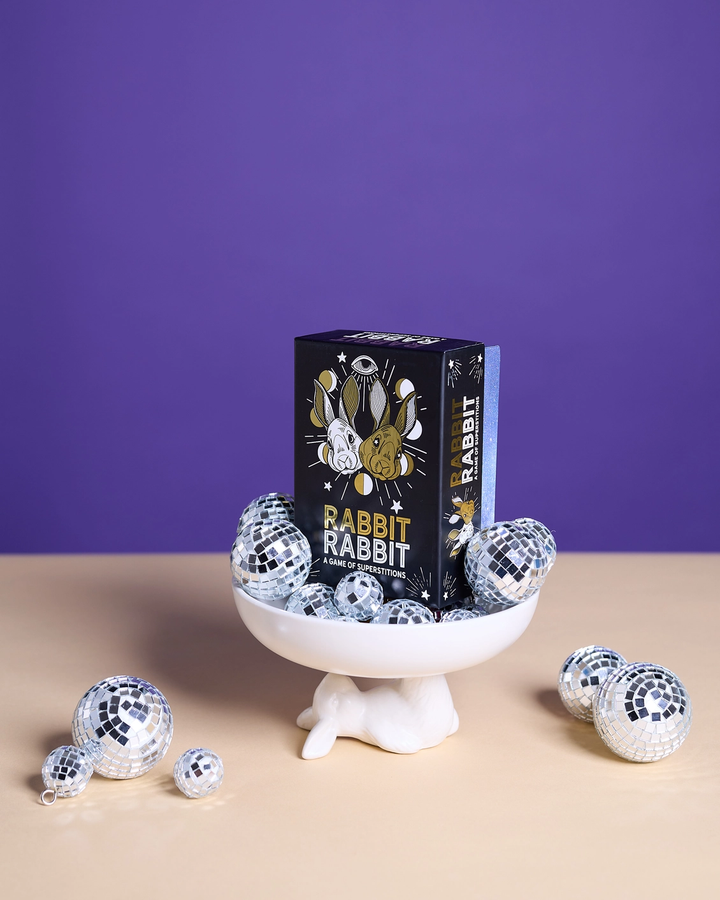 Rabbit Rabbit product packaging with disco balls on a stand against a purple background