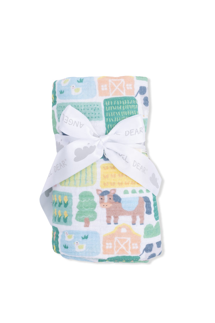Baby blanket with farm animal pattern and white bow on a white background