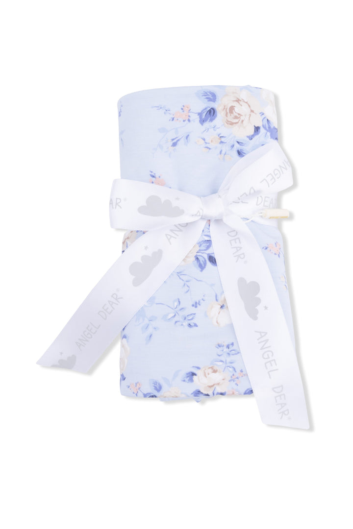 Floral-patterned baby swaddle with a white ribbon on a white background